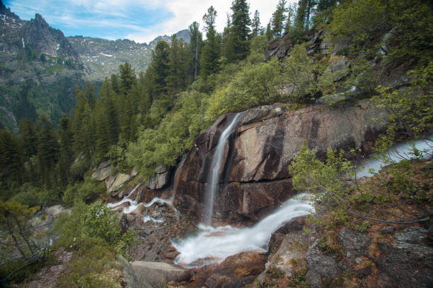 istock Gorgeous mountain scenery with a waterfall. Beautiful mountain stream and magical mountain flowers 1044319274
