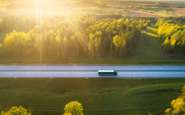 Truck on highway Truck on highway. Truck moving on road in evening. Cargo transportation background. Cargo shipping. Road with truck in sunlight and sun rays. truck mode of transport road transportation stock pictures, royalty-free photos & images
