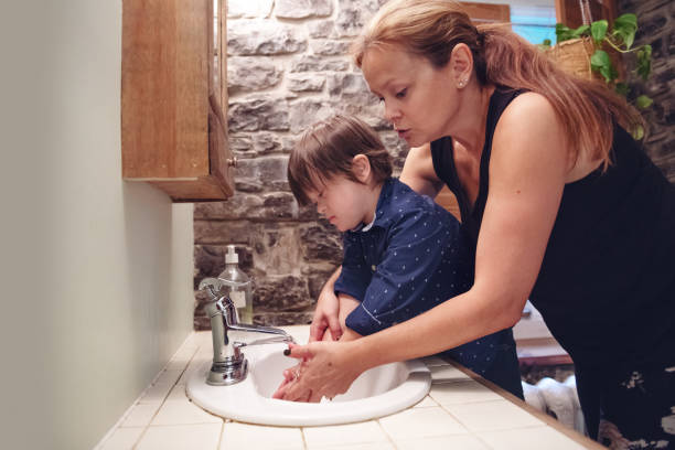 istock Little boy with down syndrome washing his hands 1044326910