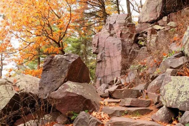 Autumn view with ice age hiking trail with colorful trees and stone stairs between rocks. Devils Lake State Park, Baraboo area, Wisconsin, USA.