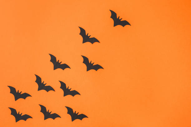 istock Paper bats arranged on orange background 1044332040
