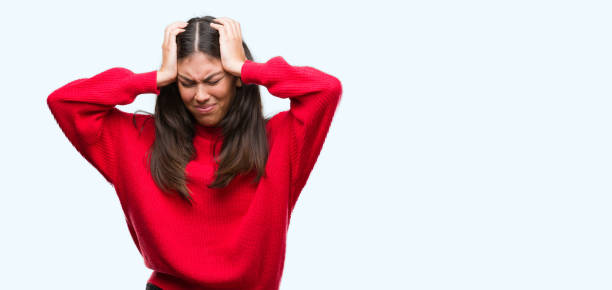 istock Young beautiful hispanic wearing red sweater suffering from headache desperate and stressed because pain and migraine. Hands on head. 1044335250