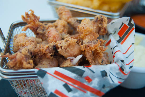 Close-up of fried little squids with white sauce on the table