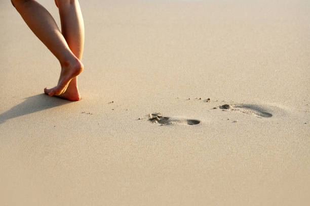 istock Female feet going on an ocean beach 1044343798