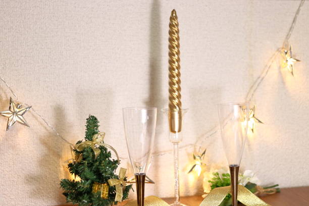 istock Two champagne glasses on the table, a Christmas tree and a candle 1044343826