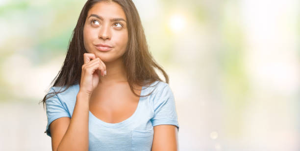 istock Young beautiful arab woman over isolated background with hand on chin thinking about question, pensive expression. Smiling with thoughtful face. Doubt concept. 1044344352