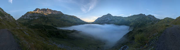 istock Mountain lake covered in fog at dawn 1044347536