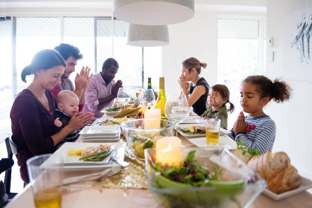 fiestas familiares y amigos multiétnica durante la cena de acción de gracias - family thanksgiving dinner praying fotografías e imágenes de stock
