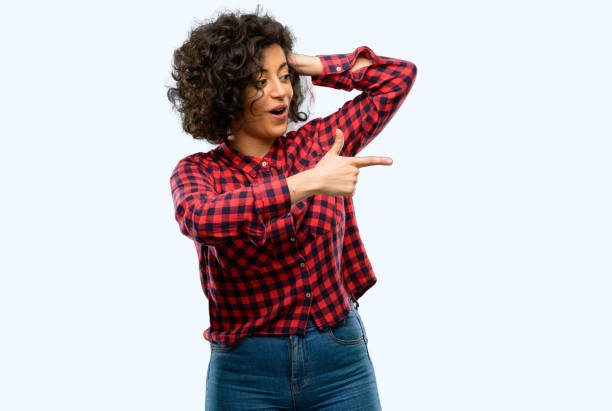 istock Beautiful arab woman pointing away side with finger 1044357678