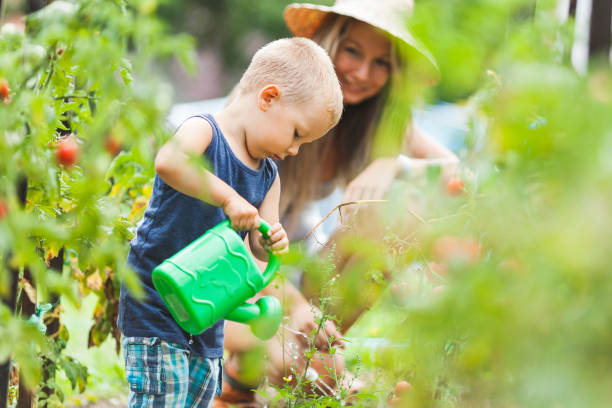 niño lindo ayudando a mamá en el jardín - school farm fotografías e imágenes de stock