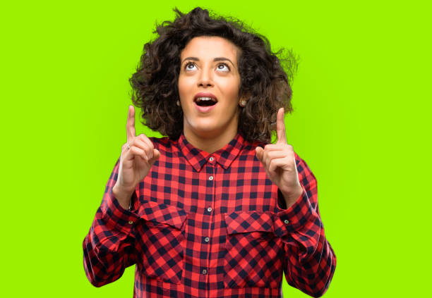 istock Beautiful arab woman happy and surprised cheering expressing wow gesture pointing up 1044358168