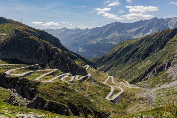 panoramic view of the road tremola in Airolo, Ticino. Sunny day with clouds cobblestone road that climbs into the valley. Swiss Alps gotthard pass stock pictures, royalty-free photos & images
