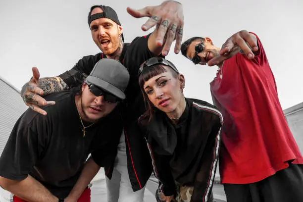 group of rappers posing on the metal rooftops of an abandoned building