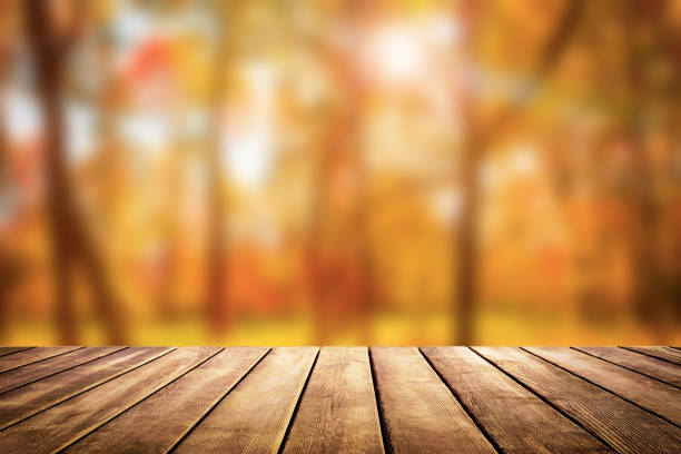 Wooden table top on blur autumn background stock photo