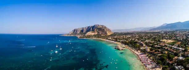 Palermo, Sicily, Italy - August 8, 2017:   view showing Sicily island, boats in the sea, trees, buildings and mountains can be seen on the background