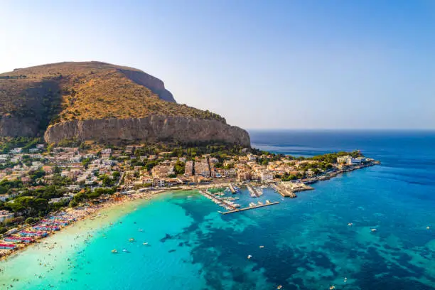 Palermo, Sicily, Italy - August 8, 2017:   view showing Sicily island, boats in the sea, trees, buildings and mountains can be seen on the background