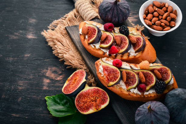istock Sandwich with figs, wild berries and cheese. On the old background. Dessert. Free space for text. Top view. 1044376412