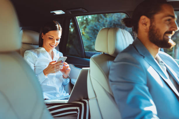 Chauffeur de limousine entraînée avec la femme d’affaires sur le siège arrière - Photo