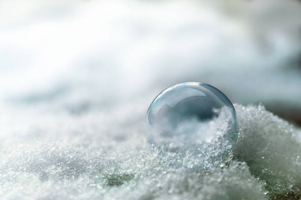 istock soap bubble in the snow, winter background with copy space, macro shot 1044377546