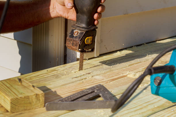 istock Carpenter cutting wood with electro saw construction porch 1044381052