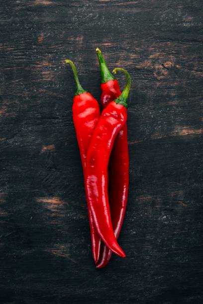 istock Chili red pepper. On a black wooden background. Free space for text. Top view. 1044382226