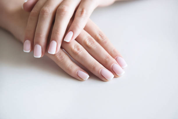 Manicured hands on towel. French manicure. stock photo