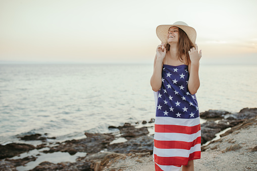 Teenage girl wearing American dress on the beach