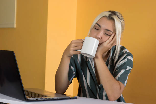 ejecutivo tranquilo tomando café en la oficina - dependency caffeine tired women fotografías e imágenes de stock