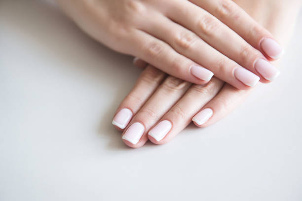 istock Manicured hands on towel. French manicure. 1044392564