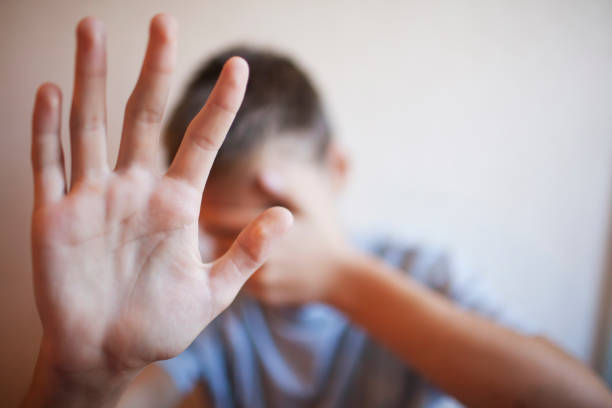 istock Boy teenager protects himself with his hands 1044396384