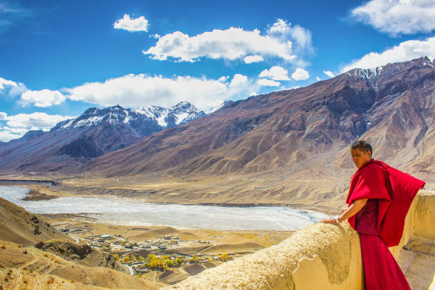 Monk enjoys the landscape beauty at Key monastery , Spiti valley, India Spiti valley, India - october 10 2015 : A monk in red robe over looks the scenic backdrop of Kye/ Key Monastery in Spiti valley in Himachal pradesh, India lahaul and spiti district photos stock pictures, royalty-free photos & images