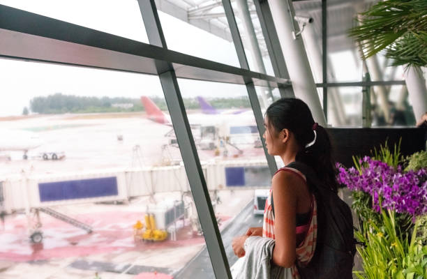 Beautiful asian woman at airport, waiting to board