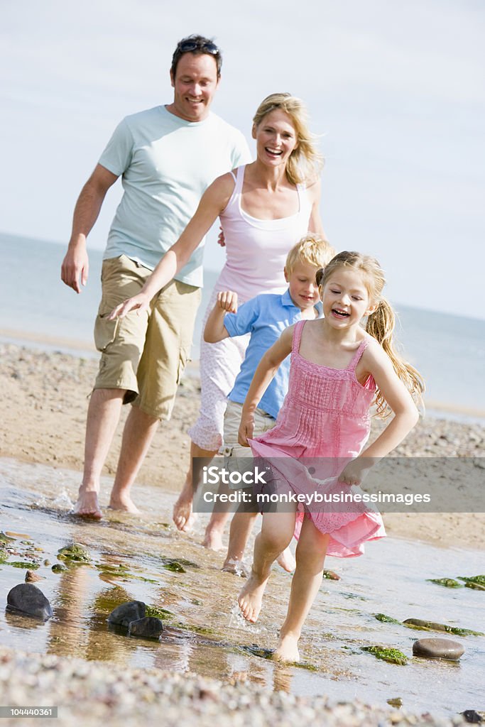 Family running at beach  30-39 Years Stock Photo