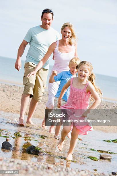 Family Running At Beach Stock Photo - Download Image Now - 30-39 Years, Adult, Adult Offspring