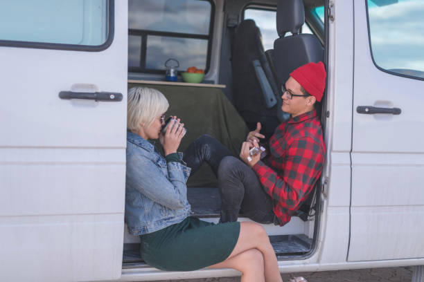 istock Hipster couple playing ukulele in their van on a camping trip 1044414182