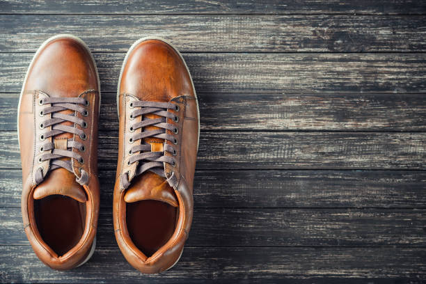 istock Brown leather men's boots on wooden background top view with copy space 1044422296