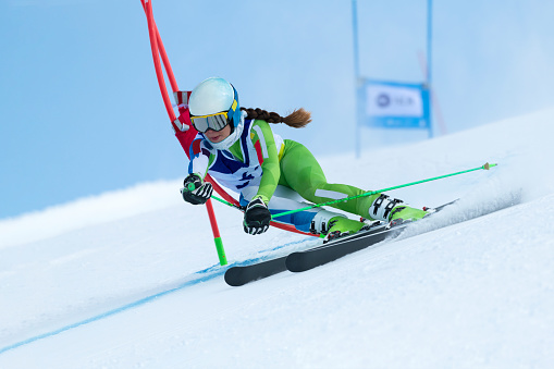 Front view of young female alpine skier at giant slalom