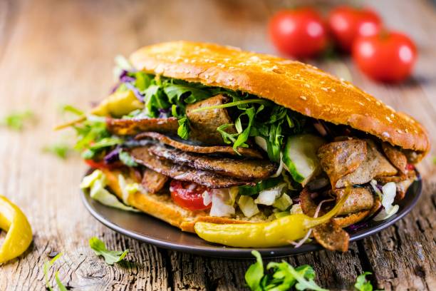 istock Delicious kebab sandwich on wooden background 1044426340