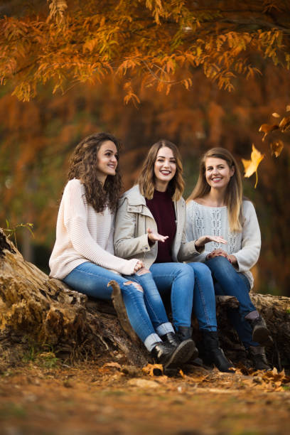 istock Three young women sitting in the forest in the autmn 1044426558