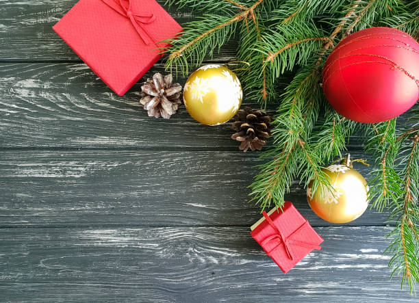 istock branch of a Christmas tree, a cone, a gift box on a wooden background 1044432678