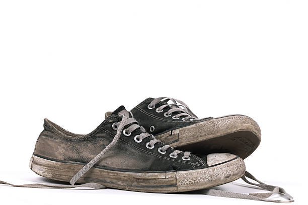 Old and dirty black canvas sneakers, isolated