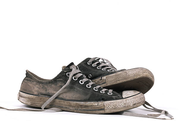 Velho e tênis de lona suja preto, isolada - foto de acervo