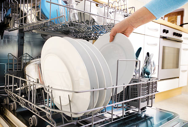 using dishwasher close-up of female hands loading dishes to the dishwasher dishwasher stock pictures, royalty-free photos & images