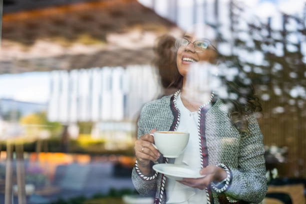 istock Brazilian woman drinking coffee and looking through window. 1044447774