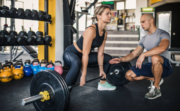 istock Girl with trainer in gym 1044453728