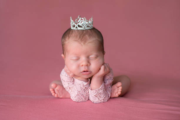 sleeping newborn baby girl wearing a tiara - royal baby imagens e fotografias de stock