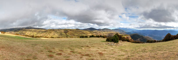 istock Blue cloudy sky and typical mountains and hills covered with forest met in autumn while hiking from the small Yebra de Basa town to Santa Orosia church on the Pyrenees mountains, Aragon, Spain 1044460230
