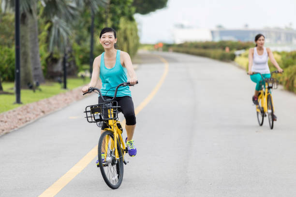istock Cheerful women ride bikes on vacation 1044468954