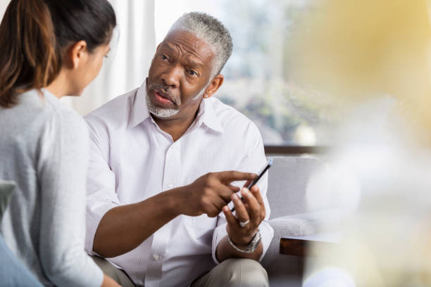 istock Senior man shows counselor something on smartphone 1044469236
