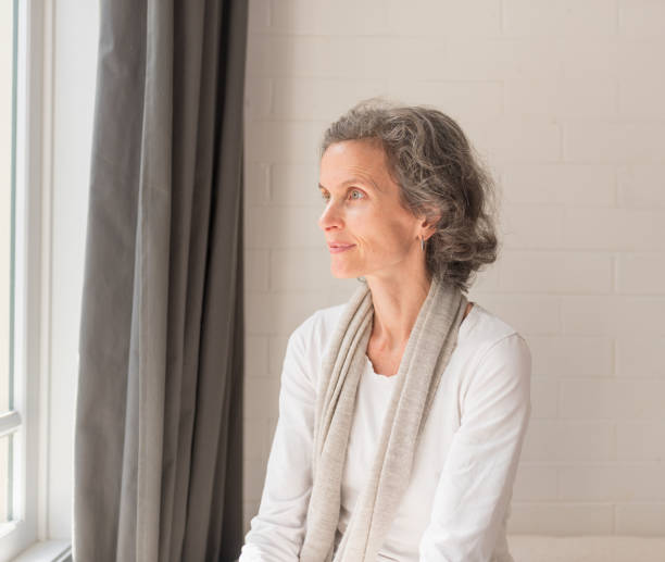 istock Beautiful middle aged woman looking towards window 1044470168